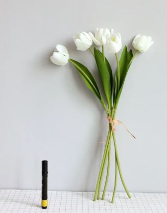 Bright artificial tulip arrangement in a decorative vase for room decor